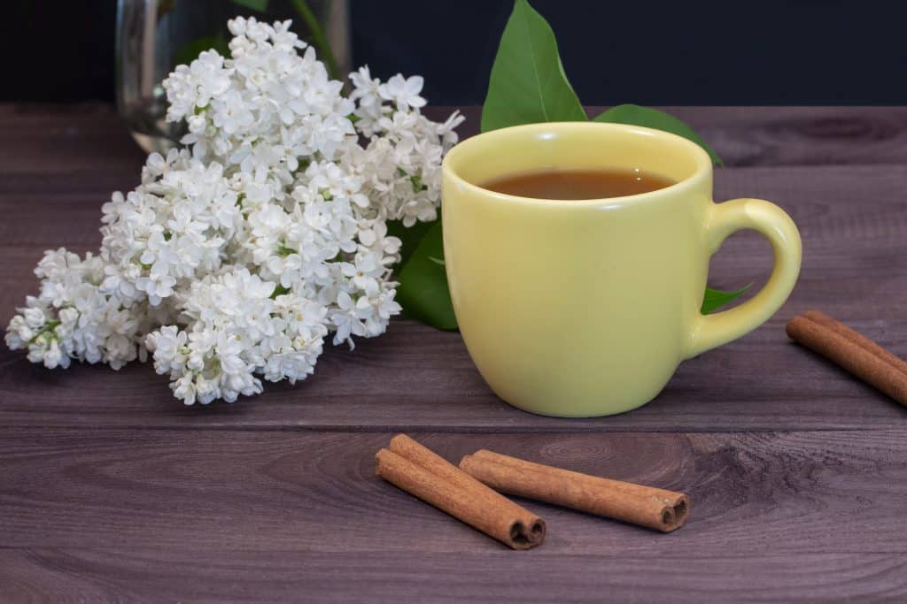 Yellow cup of tea with cinnamon