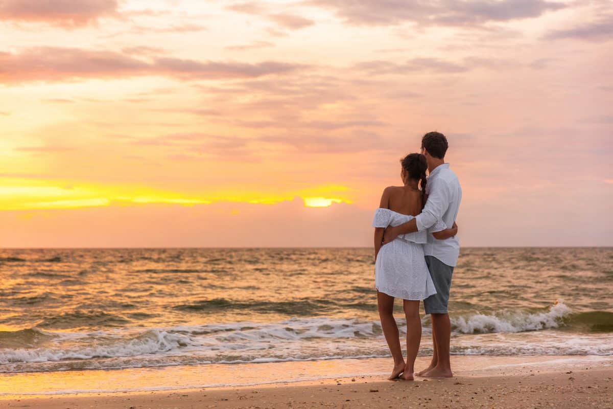 Honeymoon couple walking on sunset