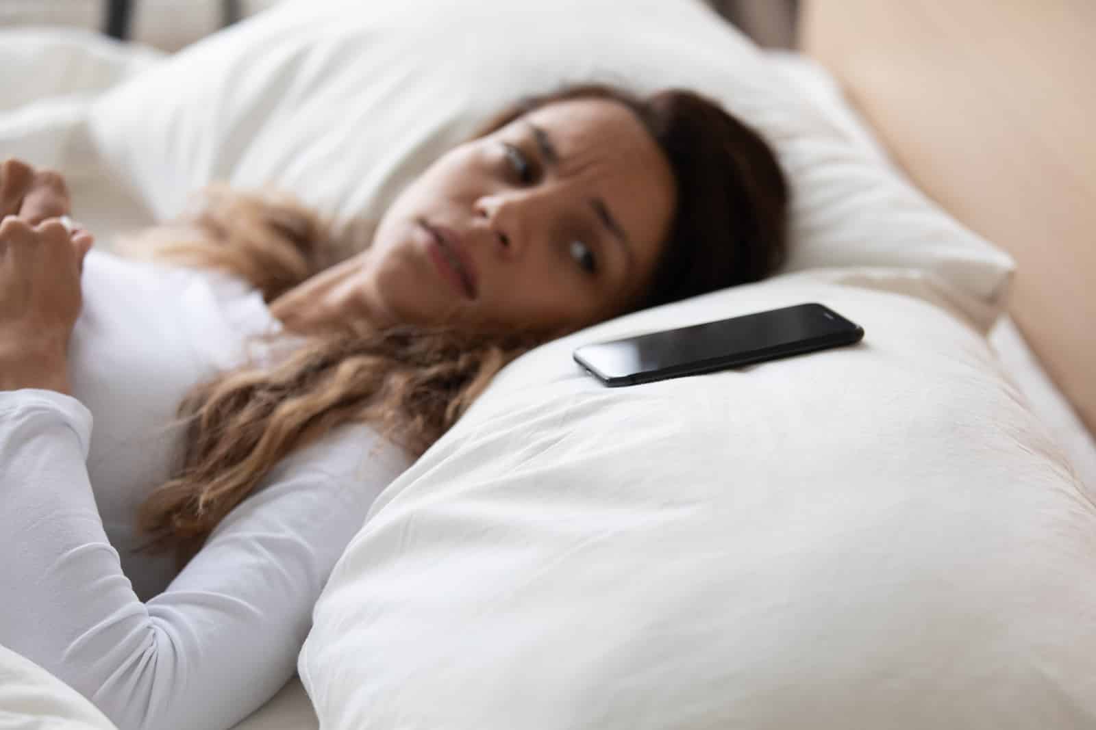 Frightened woman lying in bed