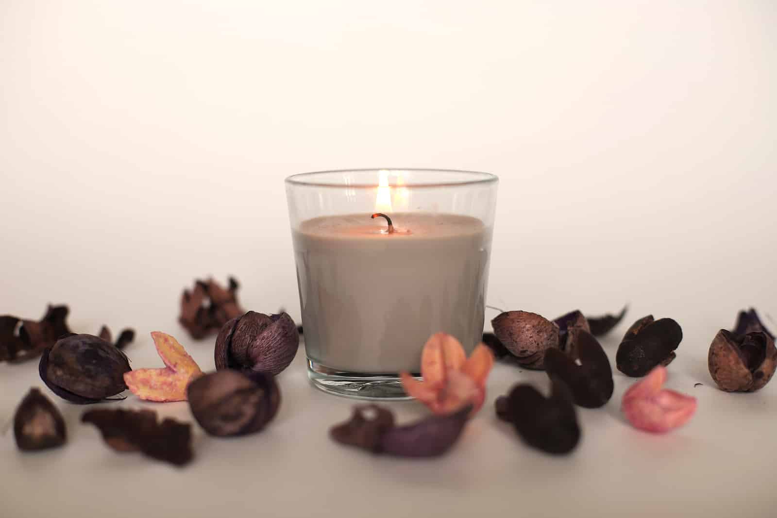 A candle in a glass with flowers scattered around, Mothers day gift
