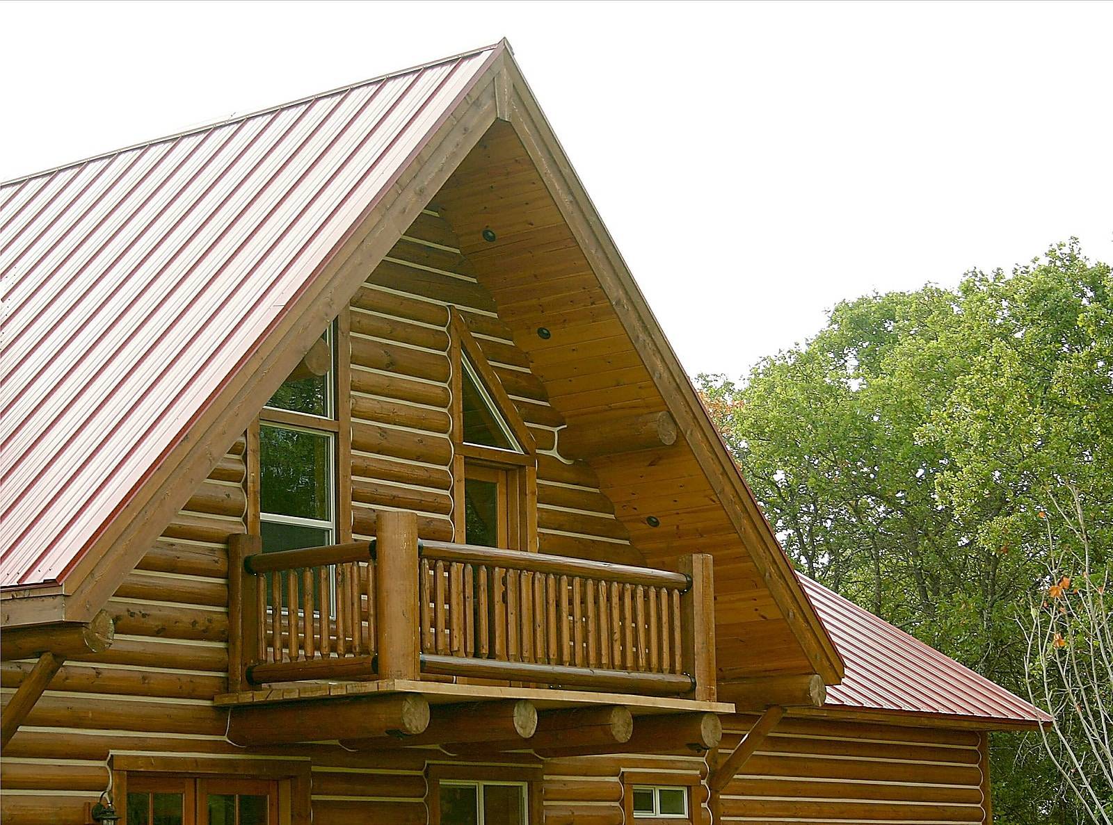 A lovely detailed balcony of a log cabin in the woods.